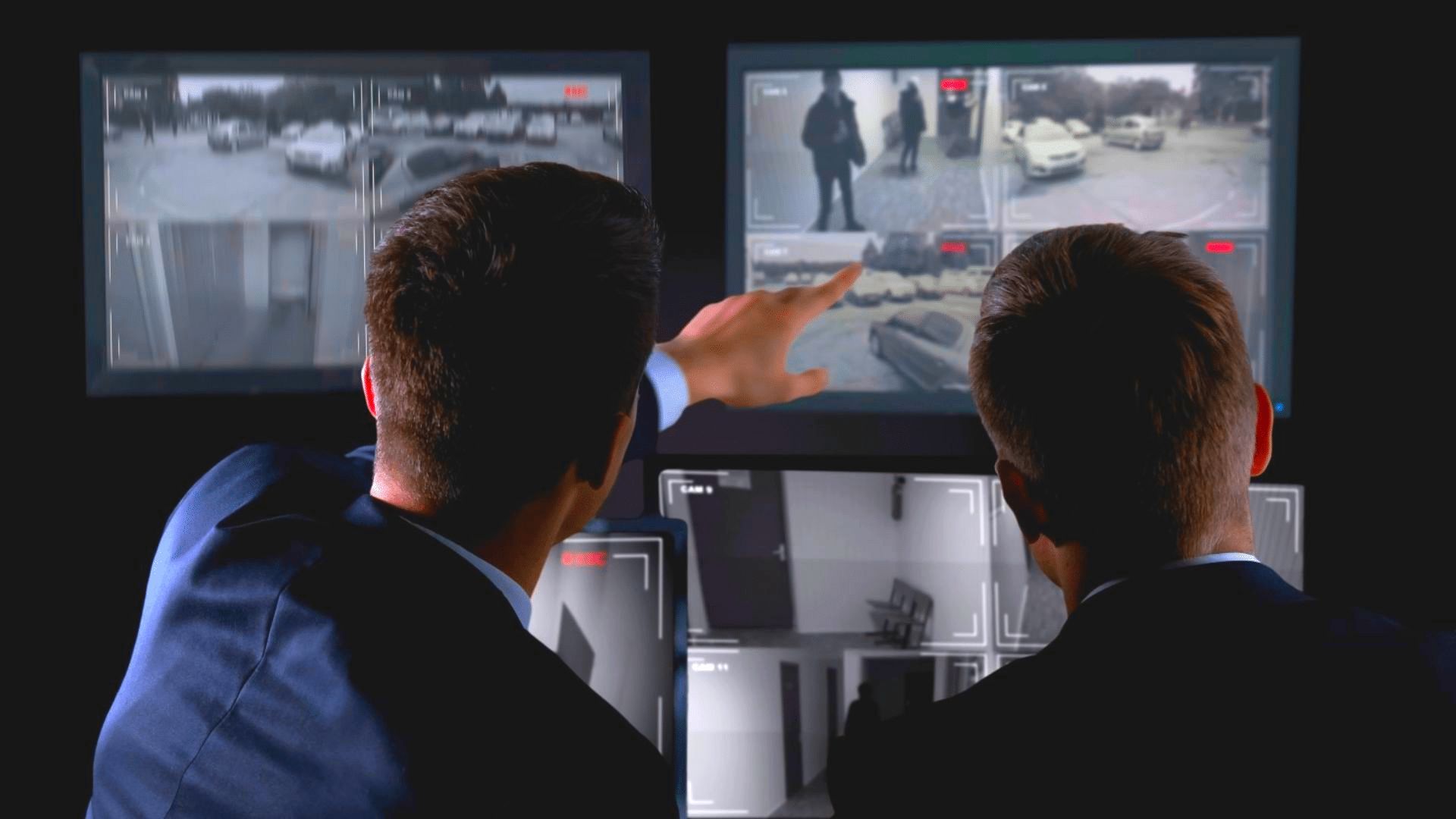 Two men looking at monitors for surveillance & security